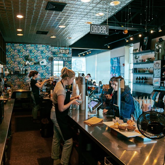 Inside Radio Coffee & Beer, baristas working the counter with pastries and merch on display