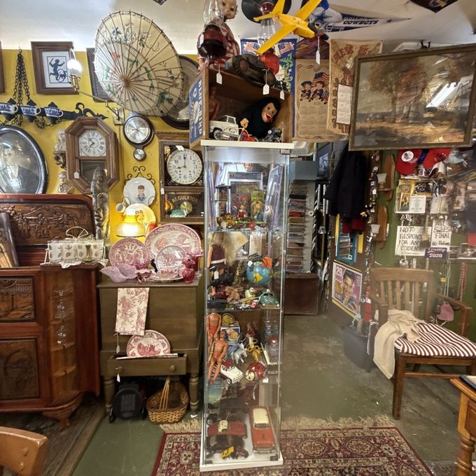 A cluttered antique and thrift shop packed with vintage toys, clocks, china and curiosities